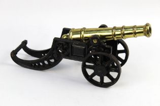 A brass cannon, length 29 cm on a cast iron carriage. Length 38 cm.