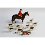 A Beswick foxhunting group with huntsman on brown horse, eight first version hounds and a fox.