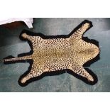 Taxidermy - A Leopard skin rug, with black felt backing. length 230 cm, width 121 cm.