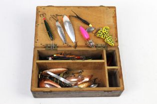 A wooden box containing +/- twenty Abu Garcia Tobys, Flying C's, Devon Minnows etc.