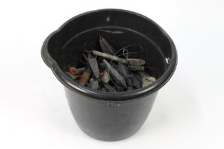 A bucket containing a large quantity of sea fishing weights.