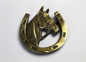 A brass door knocker in the form of a horses head and horseshoe. Length 14 cm, width 13 cm.