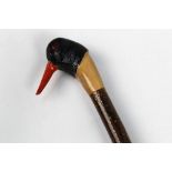 A walking stick with carved wooden handle in the form of an oyster catcher,