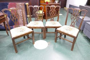 Four Chippendale style mahogany dining chairs, each with carved top rails, pierced splat backs,
