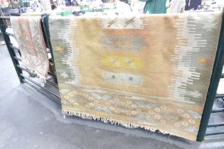Two rugs, one with cream blue and peach decoration, 112 x 86 cm, and larger one,