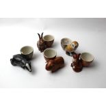 Five quail pottery egg cups, guinea pig, badger, hare,