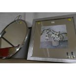 Mirrored print of flowers and round silver metal framed mirror