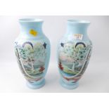 Pair of overpainted pale blue glass vases,