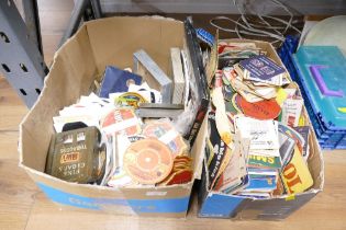 Two boxes of vintage beer mats, ashtrays,