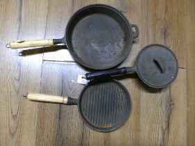 Three cast iron skillets and pans
