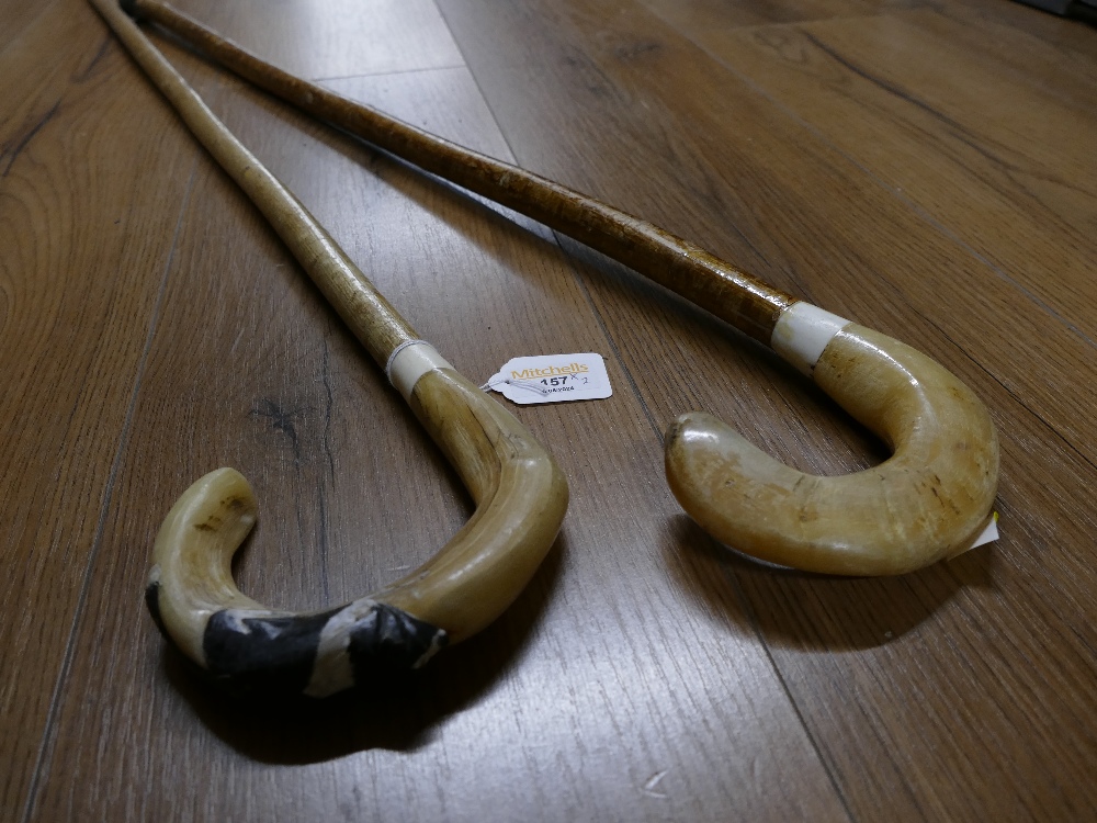 Two horn topped walking sticks one decorated with Border Collie