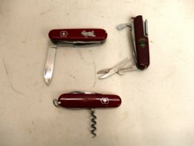 Three Swiss Army penknives, one with vin
