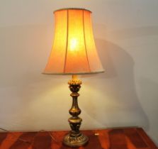 Ornate gilt wooden lamp base with pink shade,