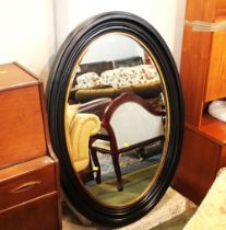Black and gold coloured oval wall mirror,