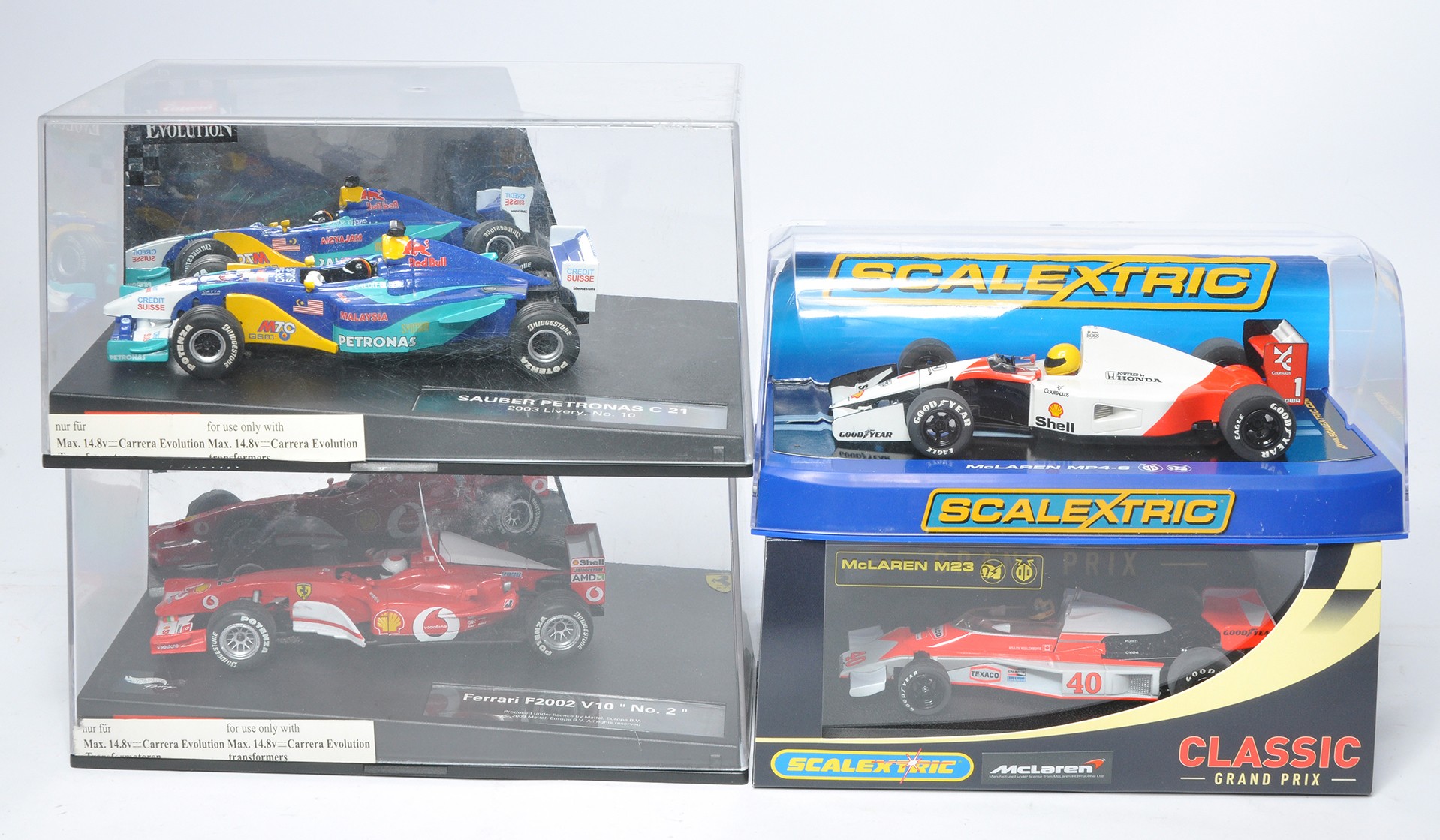 A group of four slot car issues comprising Scalextric McLaren MP4-6 plus McLaren M23 no.40,