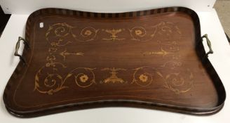 An Edwardian mahogany and inlaid twin handled drinks' tray of shaped form,