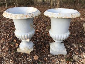 A pair of blue painted cast iron garden urns,