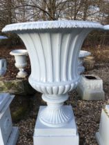 A large pair of blue painted cast iron garden urns, on plinth bases,