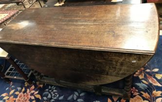 An 18th Century and later oak oval gate-leg drop-leaf dining table on barley-twist supports united