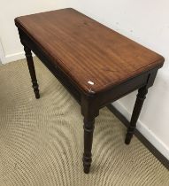 A Victorian mahogany fold over card table on turned legs 91 cm wide x 47 cm deep x 74.