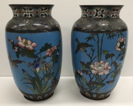 A pair of 19th Century Chinese cloisonné vases set with floral and bird decorated panels on a blue