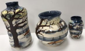 A collection of three Moorcroft "Woodside Farm" vases each decorated with snowy landscape scene