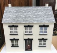 A modern bespoke dolls' house with pebble dash effect exterior and four rooms,