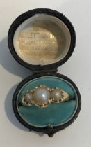 An un-marked yellow metal three stone pearl ring, 5.