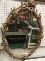 A modern carved giltwood and gesso framed oval wall mirror in the Georgian Rococo manner,