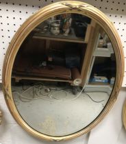 A pair of 20th Century gilt framed oval wall mirrors of ribbon tied reeded form,