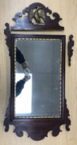A 19th Century mahogany and gilt wall mirror with Ho Ho bird finial and shaped frame with plain