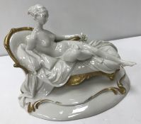 A 20th Century Giuseppe Cappe gelle Capo di Monte figure of a nude seated upon a chaise longue with