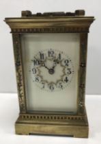A circa 1900 French lacquered brass cased carriage clock with floral and foliate enamel decorated