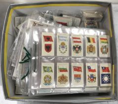 A collection of various cigarette cards including flags, mottos, emblems, signs, etc.