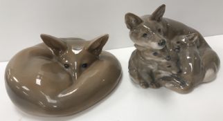 A Royal Copenhagen figure of a curled up fox No'd 438 to base 9 cm high together with a fox and cub