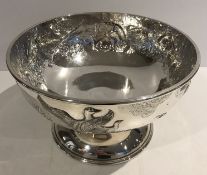 A modern silver punch bowl of circular form, the main body with embossed decoration of grouse,