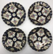 A set of four 18th Century Worcester blue ground plates with decoration of panels of flowers within