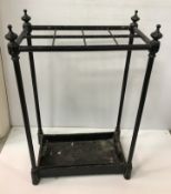 A circa 1900 black painted iron stick stand, the plain eight section top on column supports,