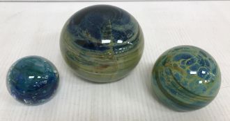 A Medina paperweight of spherical form 7 cm high together with another similar indistinctly signed