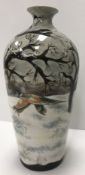 A Cobridge stoneware vase depicting a snow covered landscape with two pheasant initialled "ML" and