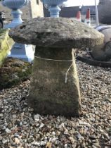 A natural stone staddle stone with top,