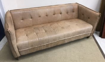 A modern mid brown leather three seat sofa with buttoned style detail,