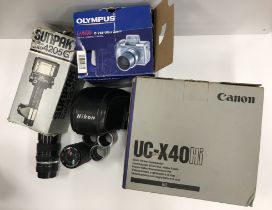 A box of assorted cameras and camera equipment to include an Olympus Camedia C-765 Ultra Zoom,