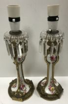 A pair of 19th Century French gilt brass mounted porcelain candlesticks with floral spray