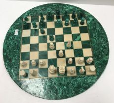 A malachite and marble circular chess board and chess pieces to match, the board 37.