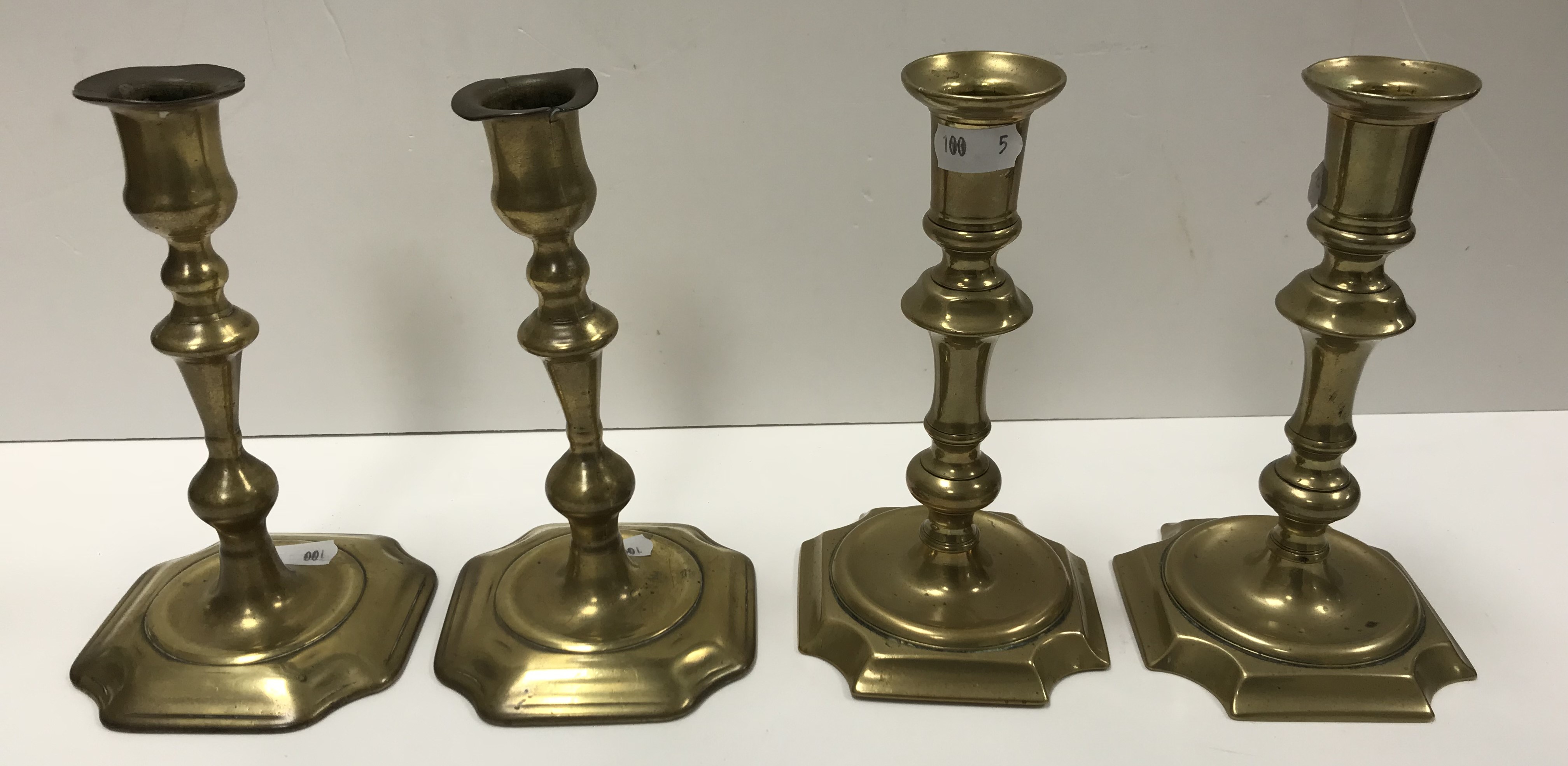 Two pairs of 18th Century brass candlesticks of typical form,