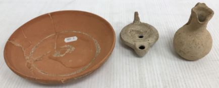 A Roman style pottery oil lamp with serpent decoration to top and impressed mark to base 10 cm long
