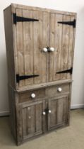 A pine kitchen dresser, the plain top over two drawers with pottery handled and two cupboard doors,