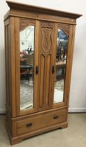 A late Victorian satin walnut mirrored two door wardrobe with single drawer below, 113 cm wide x 52.