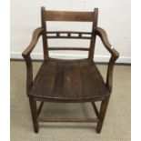 A 19th Century Norfolk fruit wood bar back elbow chair with typical dished seat on square tapered